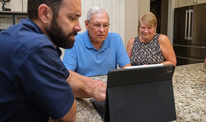 Technician reviewing system diagnostics with homeowners Technician reviewing system diagnostics with homeowners