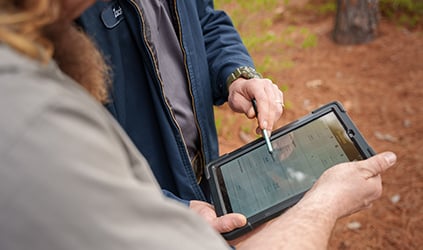 Technician reviewing estimate on tablet with customer Technician reviewing estimate on tablet with customer