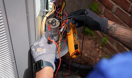 Technician testing outdoor HVAC system Technician testing outdoor HVAC system