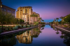 Evening view of Scottsdale, AZ on the waterfront, with a purple and blue sunset.